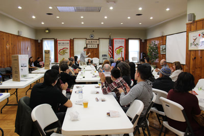 Members applaud speaker at Pacific Atrocities Education Summer Showcase and Fundraiser event