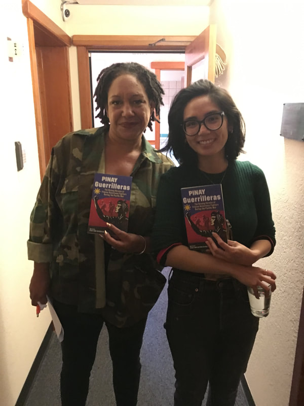 Two individuals hold "Pinay Geurrilleras" book